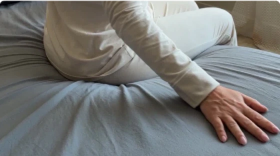 Person sitting on a grey Velin grounding sheet
